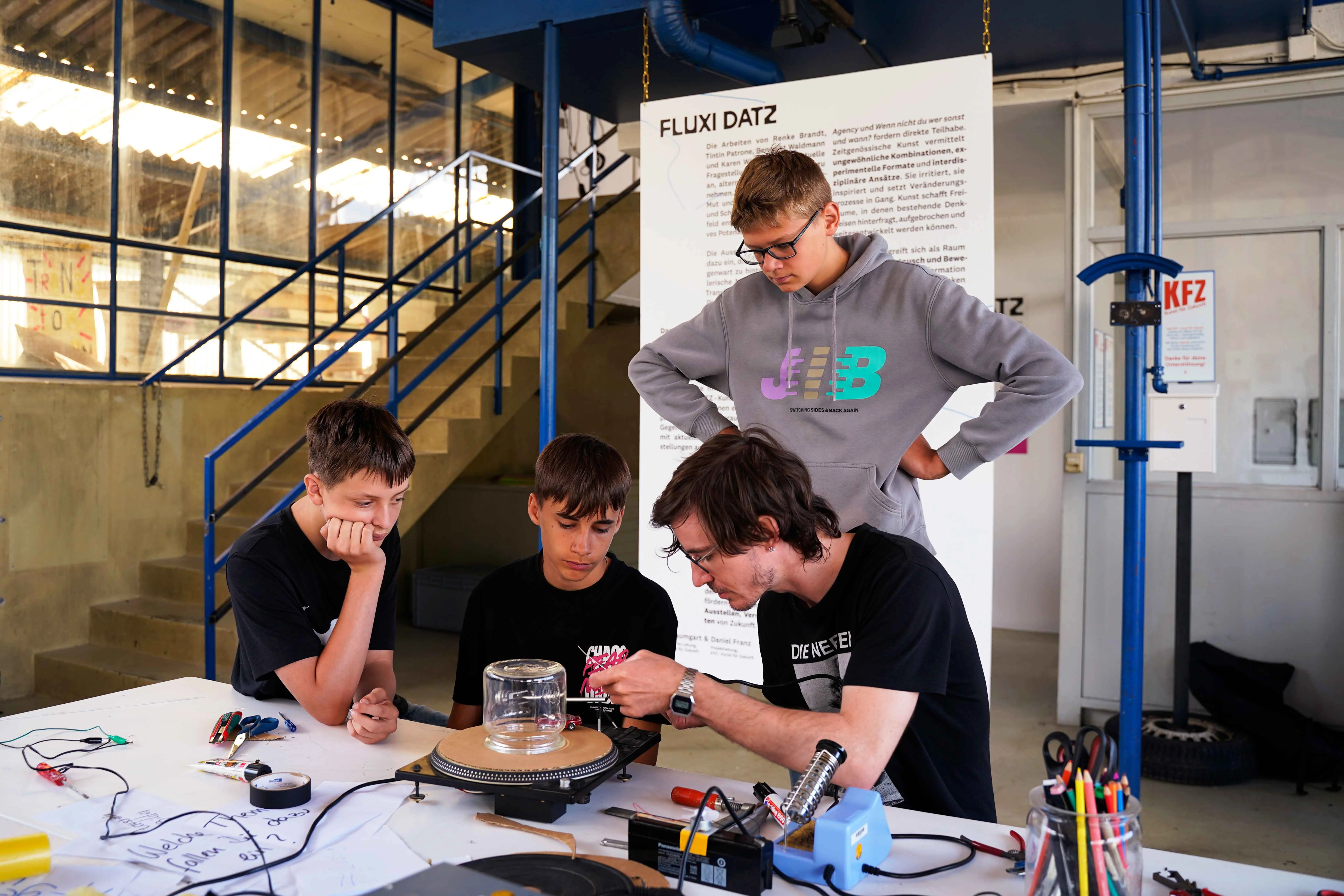 Schüler beim entwickeln ihrer Kunstwerke mit Benedikt Waldmann im KFZ, 2025