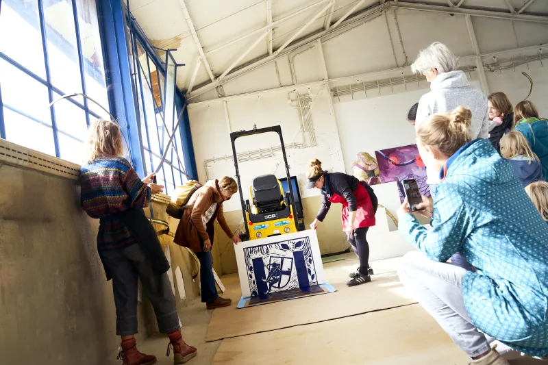 Teilnehmende mit dem frischen Druck im workshop Eine Botschaft - Ein kollektives Bild, Sept. 2024, gefördert von dem Bundesprogramm Demokratie leben!